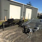 Black and galvanised tiny home trailer chassis side-by-side at Warragul yard.