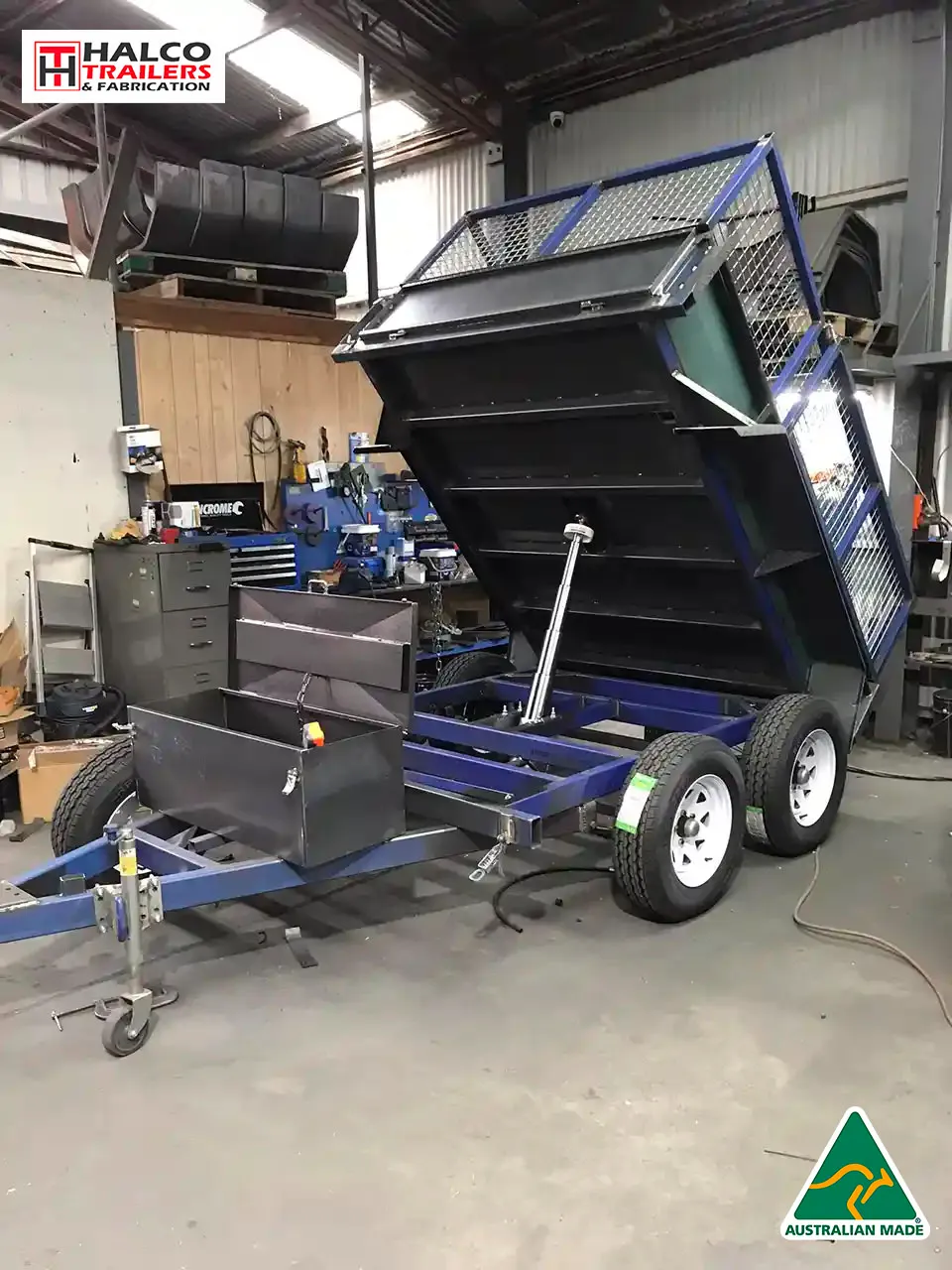 Black hydraulic tipper trailer in the workshop with hydraulic lifting system being tested.